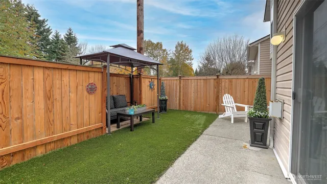 a view of a chair and table in backyard of the house