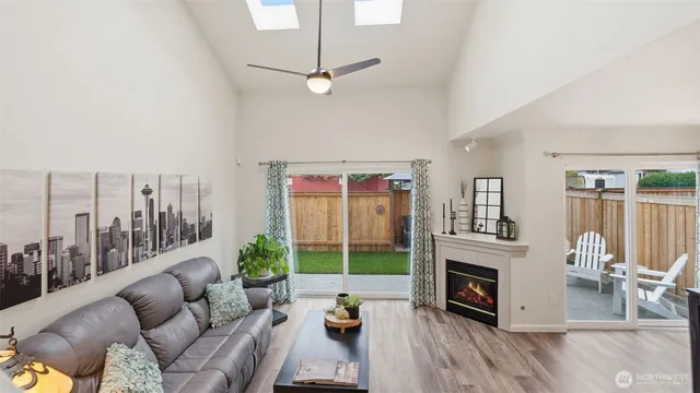 a living room with furniture a fireplace and a floor to ceiling window