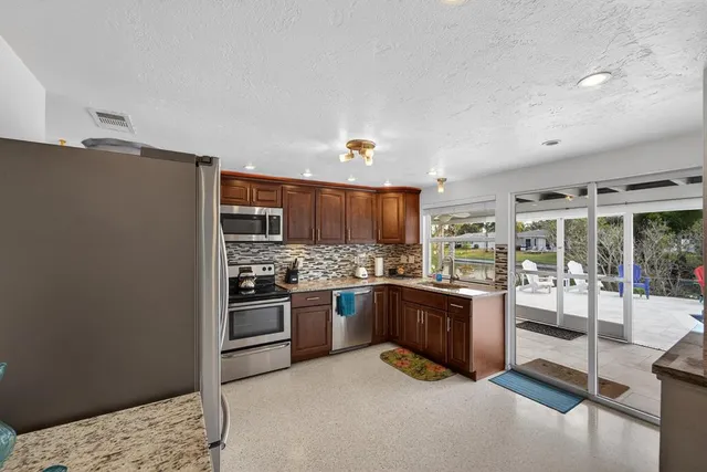 a kitchen with stainless steel appliances granite countertop a stove and a refrigerator