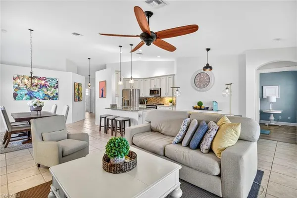 a living room with furniture kitchen view and a chandelier