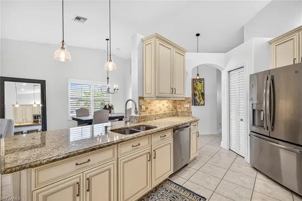 a kitchen with granite countertop a sink a counter space appliances and cabinets