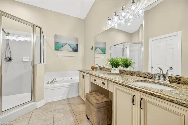 a bathroom with a granite countertop sink a large mirror a shower and a bathtub