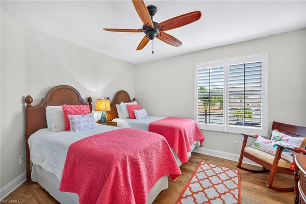 a bedroom with two beds and a large window
