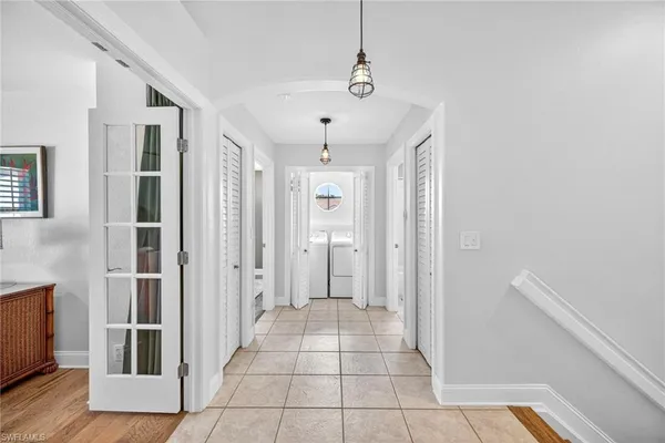 a view of a hallway with wooden floor and cabinet