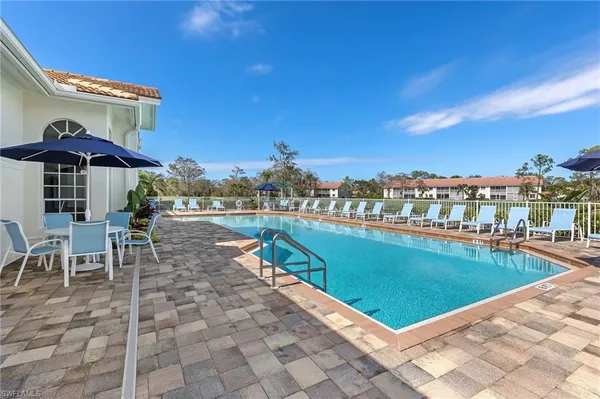 a view of a swimming pool with a patio and palm trees