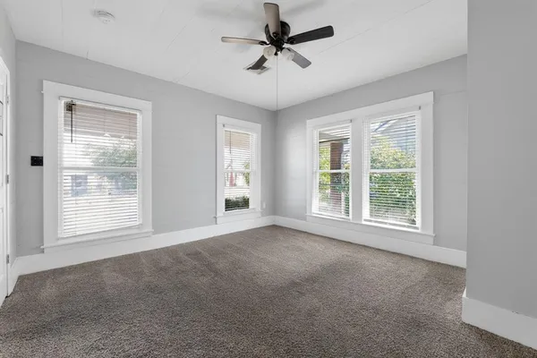 a view of a livingroom with a ceiling fan and windows