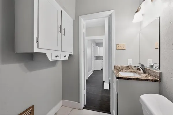 a bathroom with a granite countertop sink a mirror and shower