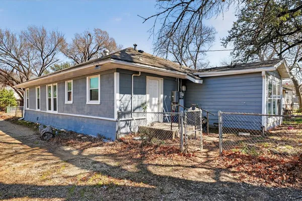 a backyard of a house with yard table and chairs
