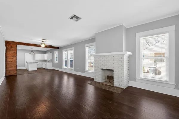 a view of empty room with wooden floor and fireplace