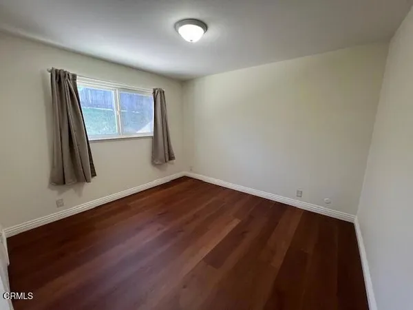 an empty room with wooden floor and a window