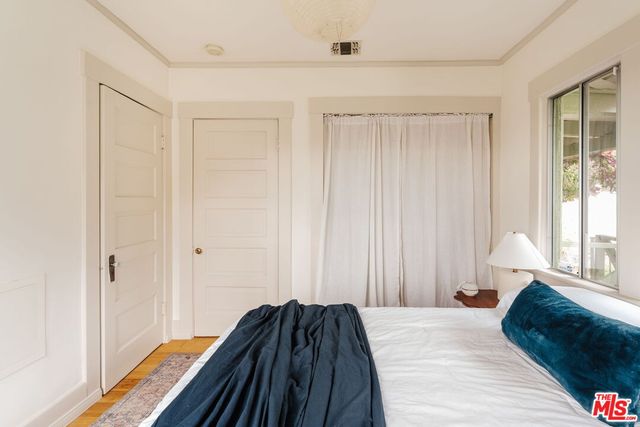 a bedroom with a bed and painting on the wall