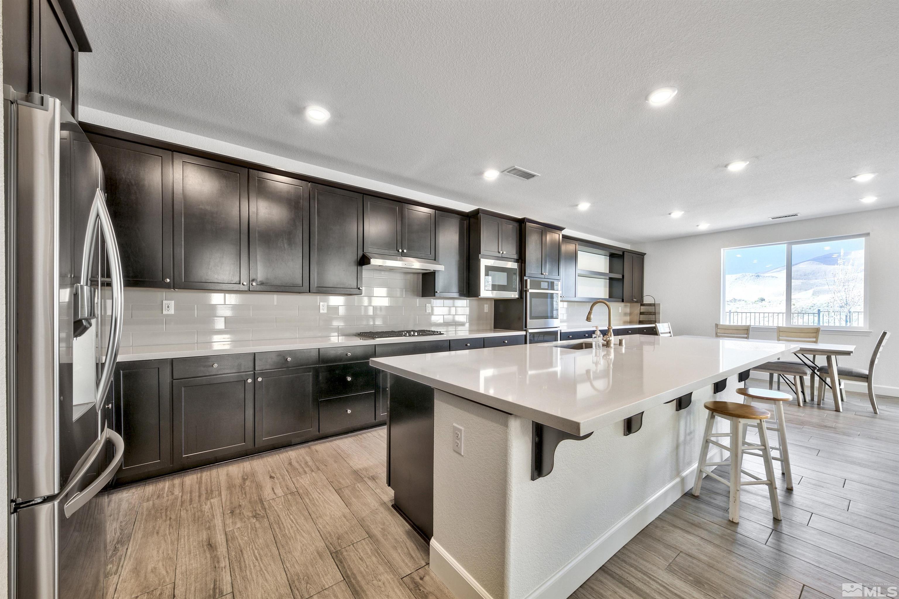 4505 High Pointe Drive Reno, NV 89521 - Photo 15 of 30 a large kitchen with stainless steel appliances granite countertop a lot of counter space and wooden floors