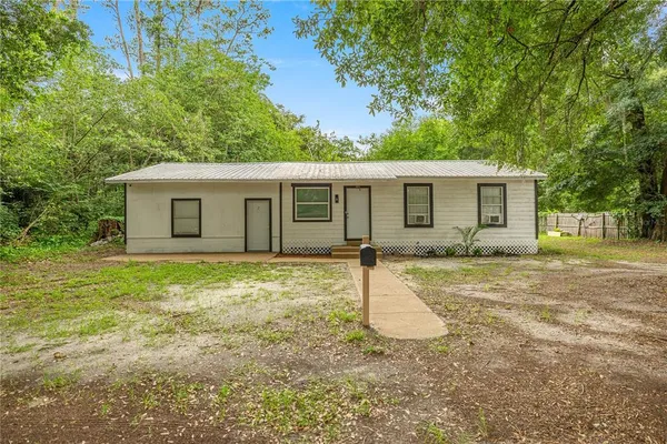 a view of a house with backyard and a tree