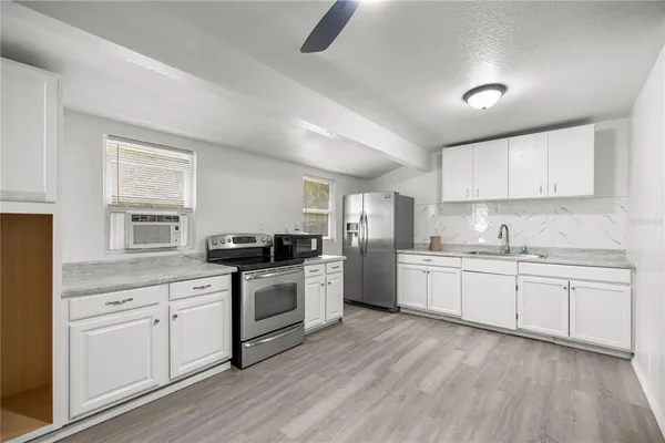 a kitchen with granite countertop white cabinets and white appliances