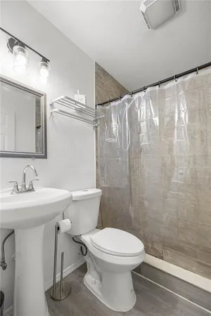 a bathroom with a toilet a sink and shower