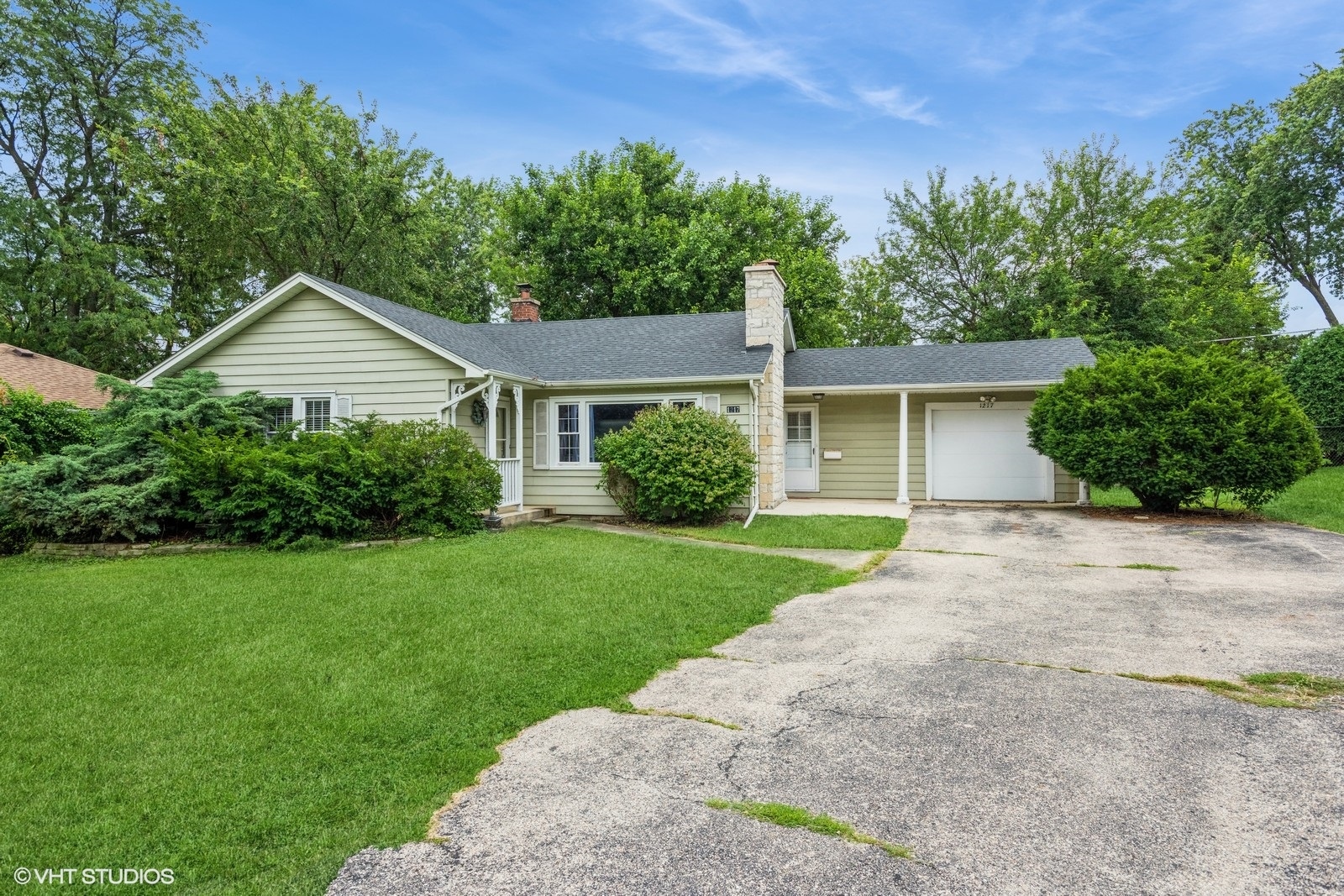 1217 South Naperville Road Wheaton, IL 60189 - Photo 1 of 13 a front view of a house with a yard and garage