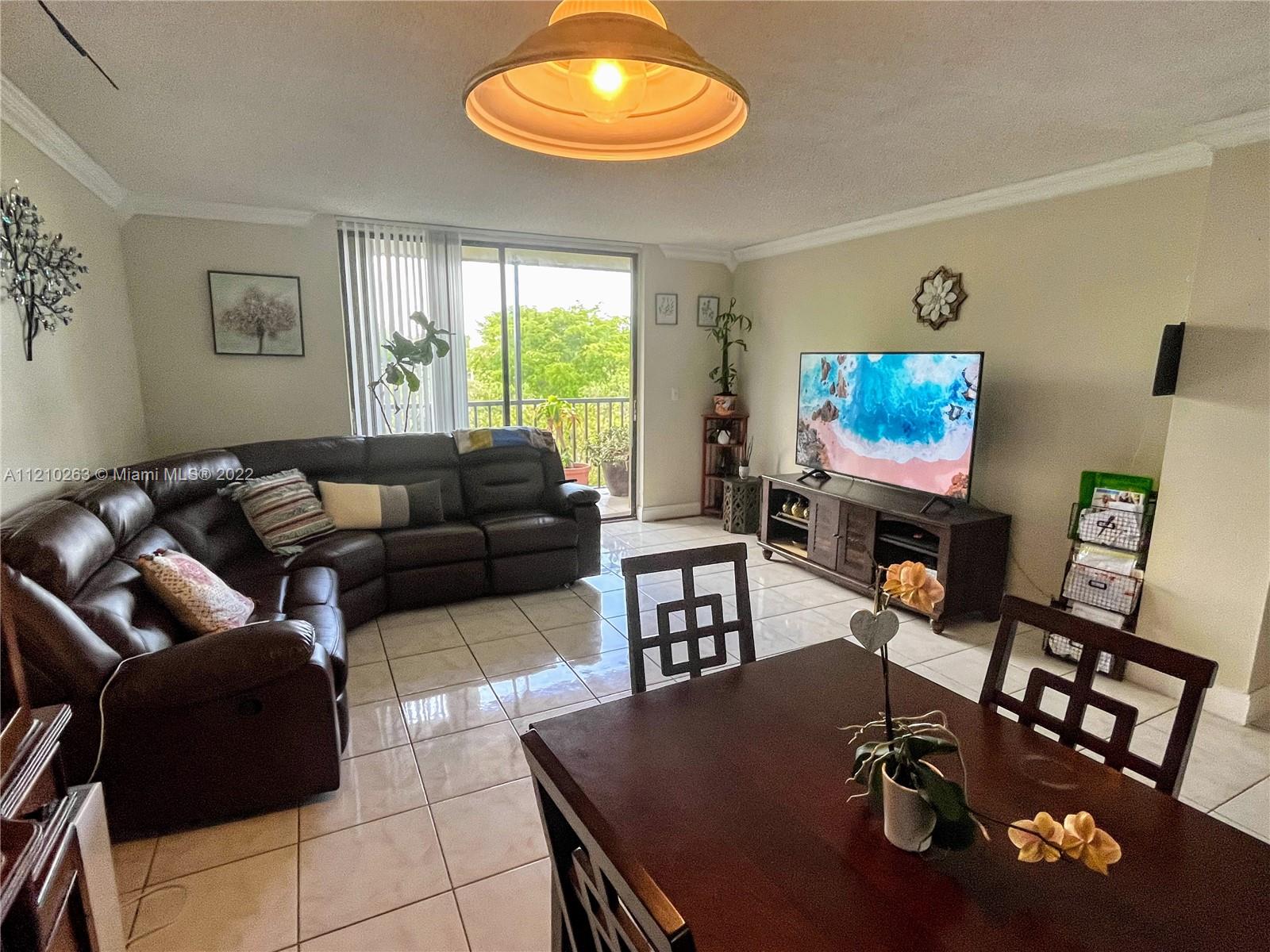 8650 Southwest 133rd Avenue Road, Unit 417 Miami, FL 33183 - Photo 2 of 14 a living room with furniture and a flat screen tv