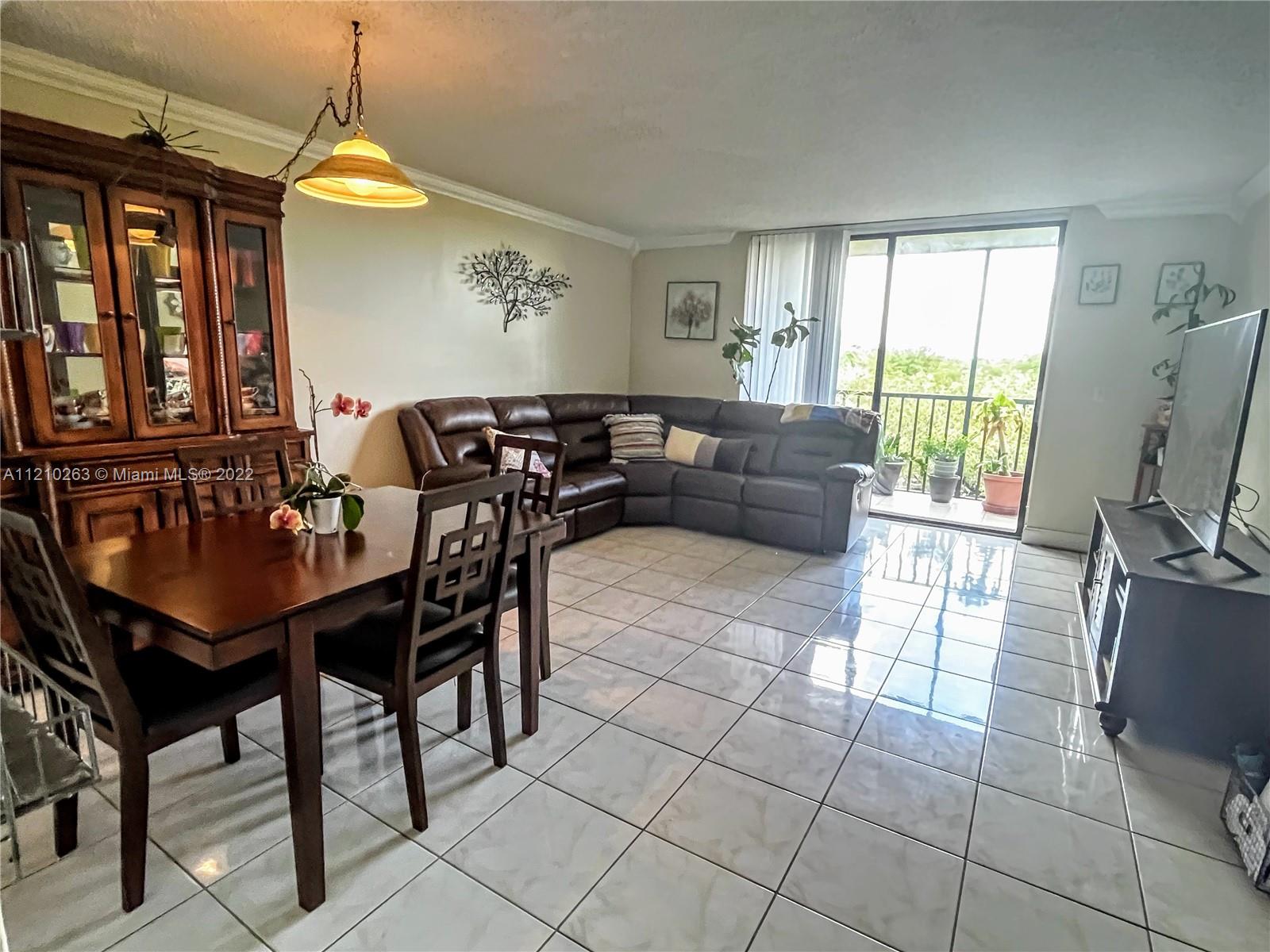 8650 Southwest 133rd Avenue Road, Unit 417 Miami, FL 33183 - Photo 3 of 14 a living room with furniture a window and a chandelier