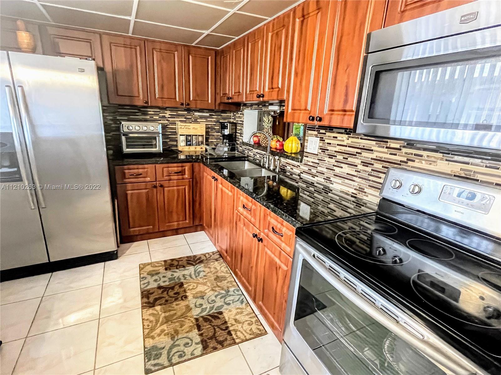 8650 Southwest 133rd Avenue Road, Unit 417 Miami, FL 33183 - Photo 4 of 14 a kitchen with stainless steel appliances a refrigerator sink and cabinets
