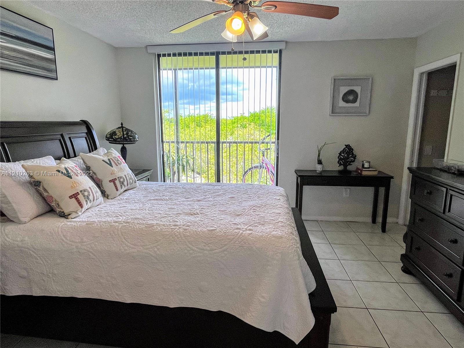8650 Southwest 133rd Avenue Road, Unit 417 Miami, FL 33183 - Photo 7 of 14 a bedroom with a bed and a flat tv screen on dresser