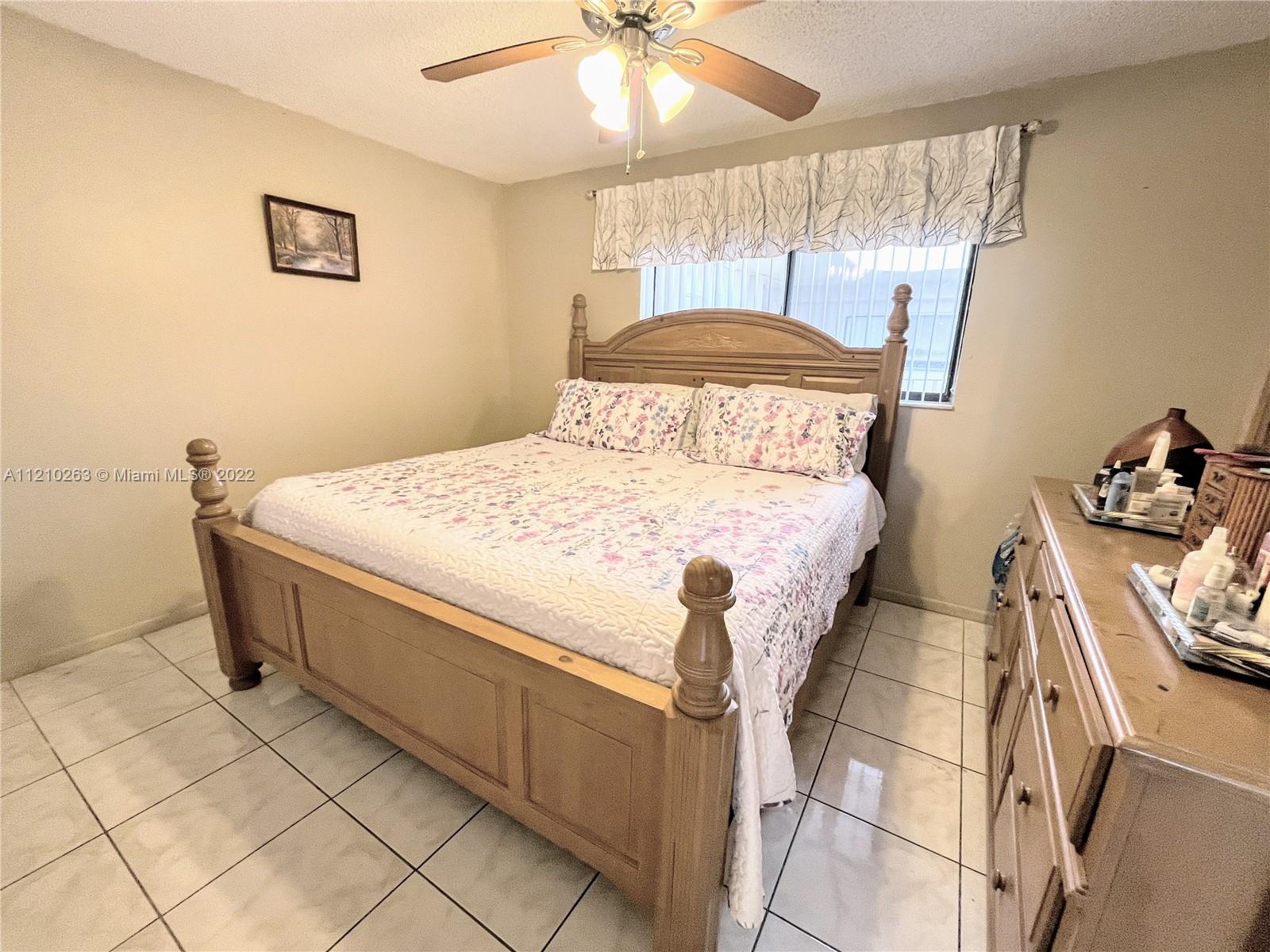 8650 Southwest 133rd Avenue Road, Unit 417 Miami, FL 33183 - Photo 9 of 14 a bedroom with a bed and a chandelier