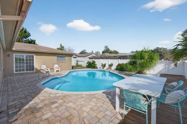 a view of backyard with swimming pool and outdoor seating