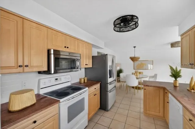 a kitchen with stainless steel appliances a stove a sink a microwave and a refrigerator