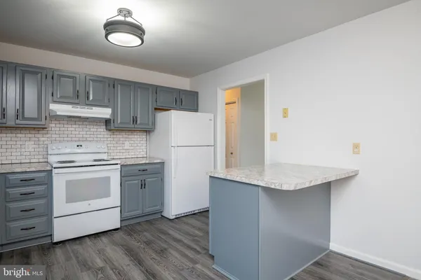 a kitchen with a sink a stove a refrigerator and cabinets
