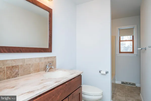 a bathroom with a granite countertop sink a toilet and shower