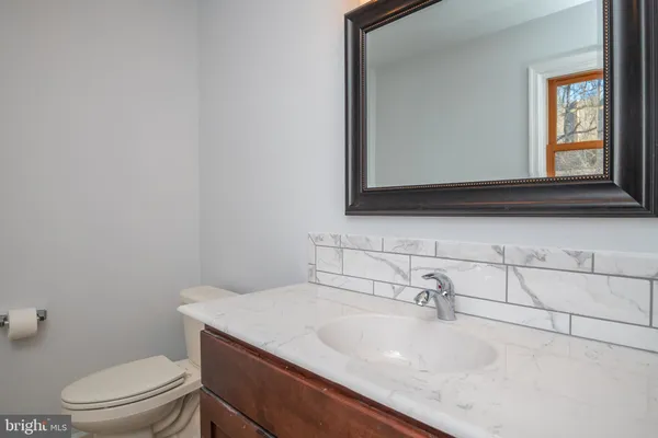a bathroom with a sink a toilet and mirror