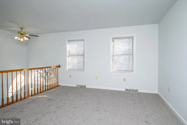 an empty room with a window and a ceiling fan