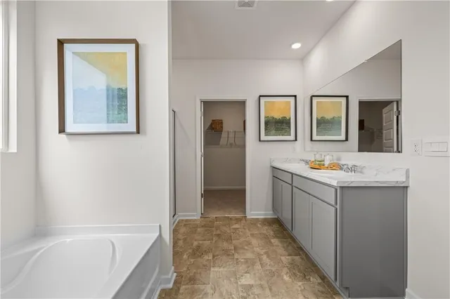 a bathroom with a bathtub sink and mirror