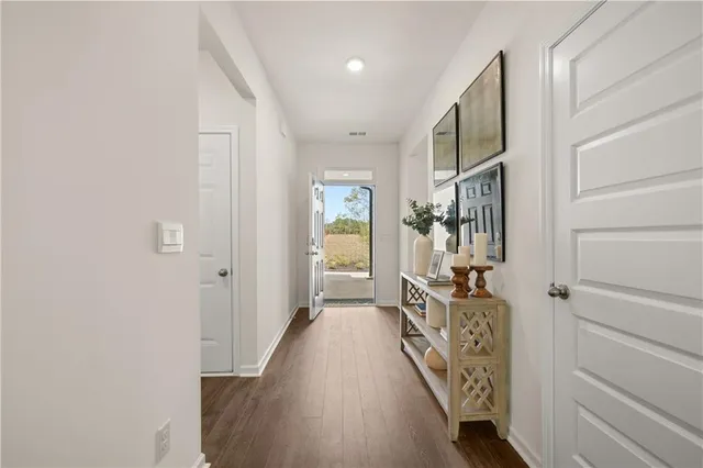 a hallway with wooden floor windows and stairs