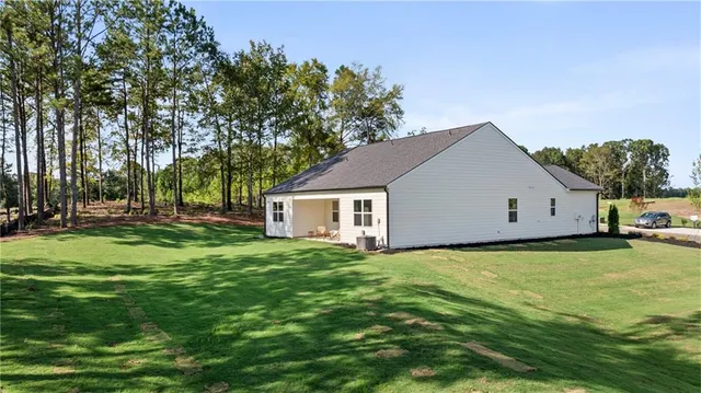 a front view of a house with a garden and trees