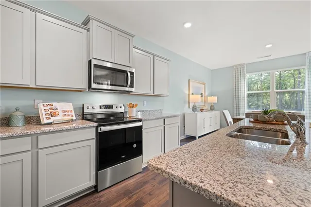 a kitchen with granite countertop a stove sink and cabinets