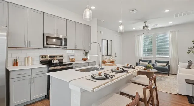 a kitchen that has a lot of cabinets a sink and a stove in it