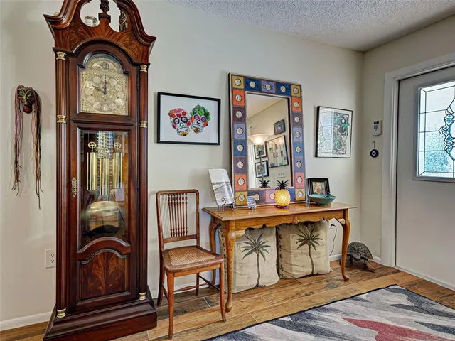 a bedroom with a bed and dresser with wooden floor