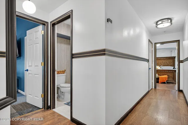 a view of a hallway with wooden floor and a living room