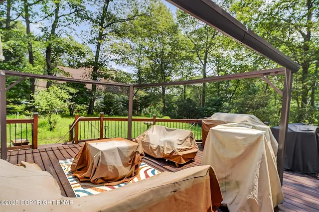 a view of deck with furniture and trees