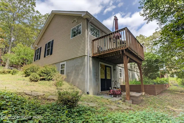 a view of a house with a small yard plants and large tree