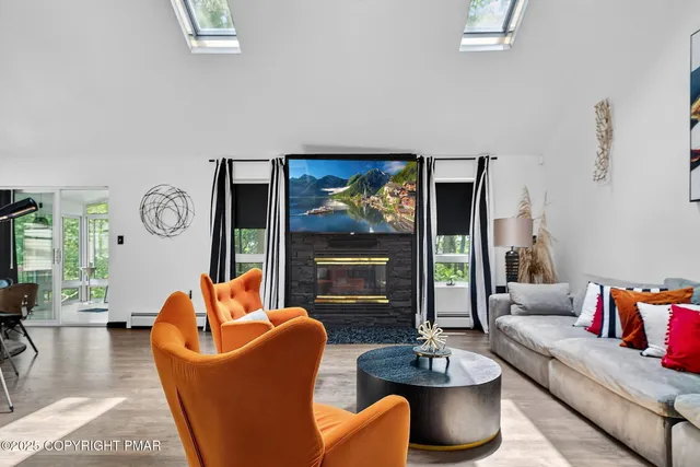 a living room with fireplace furniture and a large window