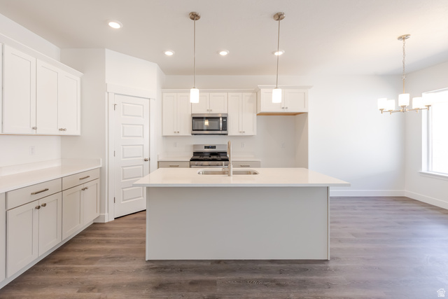 5287 South Acacia Drive, Unit 714 Mapleton, UT 84664 - Photo 5 of 21 Modern kitchen featuring white cabinetry, a central island with an undermount sink, stainless steel appliances, and wood-finish flooring