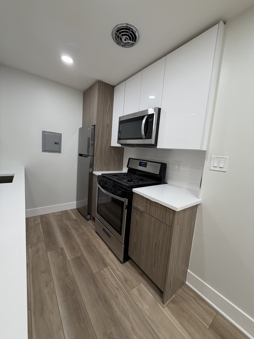 452 West Aldine Avenue, Unit 427 Chicago, IL 60657 - Photo 2 of 10 a kitchen with stainless steel appliances a refrigerator and a stove top oven