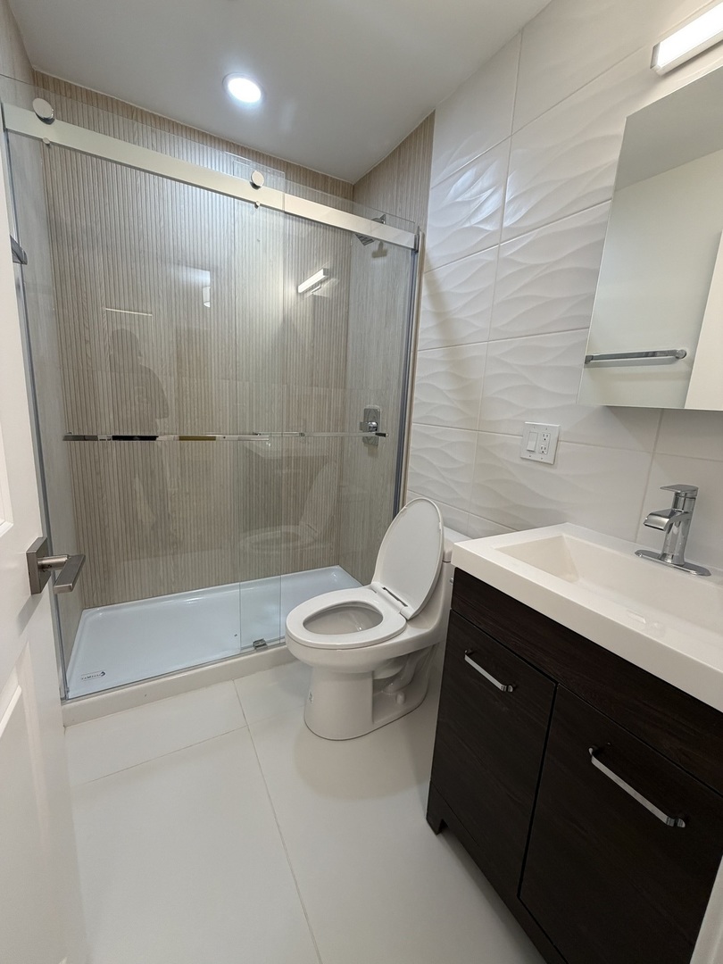 452 West Aldine Avenue, Unit 427 Chicago, IL 60657 - Photo 5 of 10 a bathroom with a sink a toilet and shower