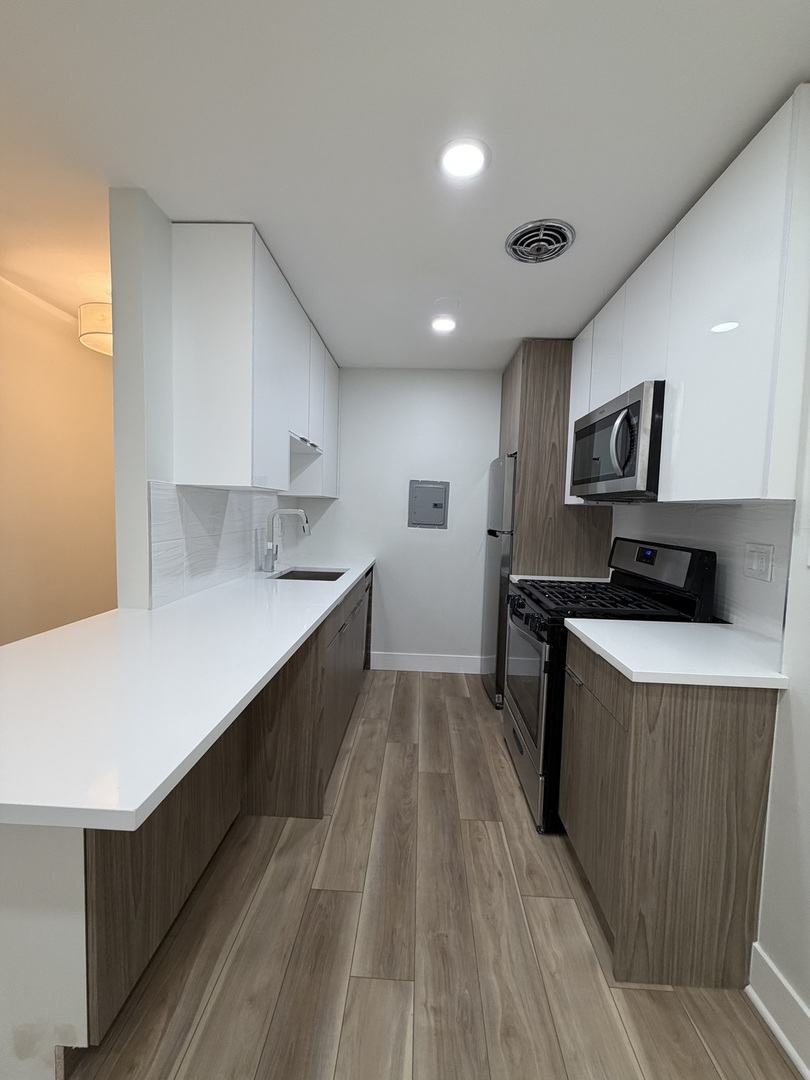 452 West Aldine Avenue, Unit 427 Chicago, IL 60657 - Photo 9 of 10 a kitchen with stainless steel appliances a refrigerator sink and white cabinets