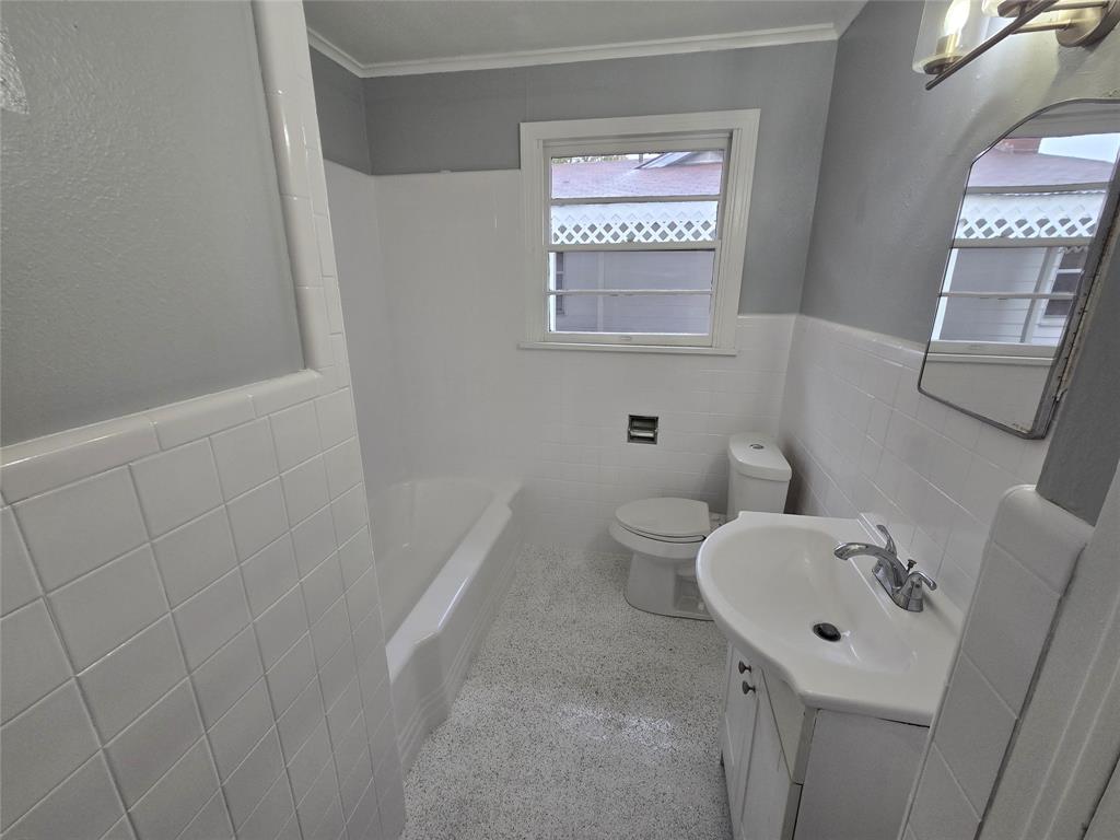 233 Roma Drive Shreveport, LA 71105 - Photo 12 of 12 Full bathroom featuring tile walls, vanity, wainscoting, shower combination, and ornamental molding