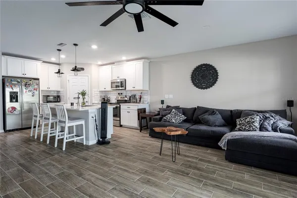 a living room with furniture and a wooden floor