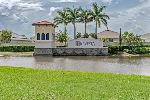 a front view of a house with a yard and a pond
