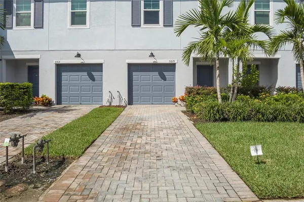 a front view of a house with a yard and potted plants