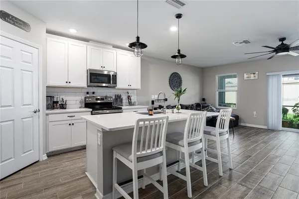 a kitchen with a center island stainless steel appliances and cabinets